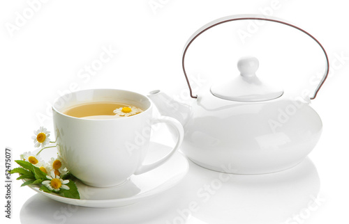 Cup and teapot of herbal tea with wild camomiles and mint,