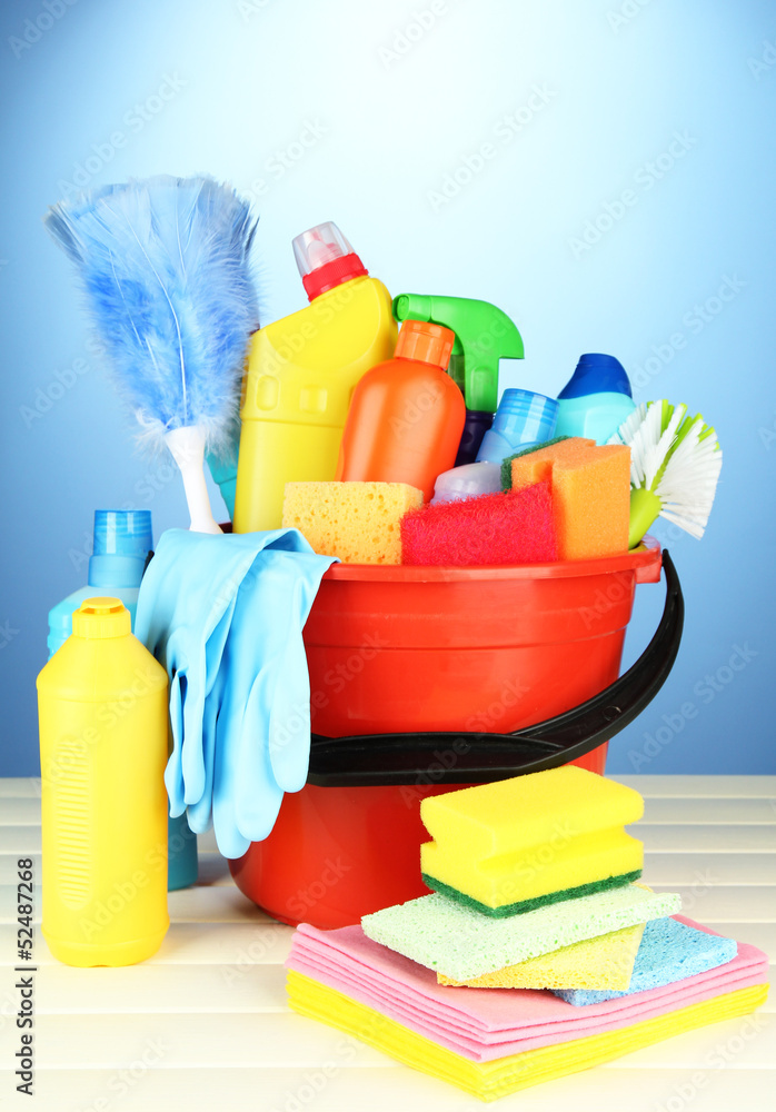 Cleaning items in bucket on color background Cleaning items in bucket on color background