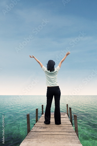 Asian woman raise hand on beach deck