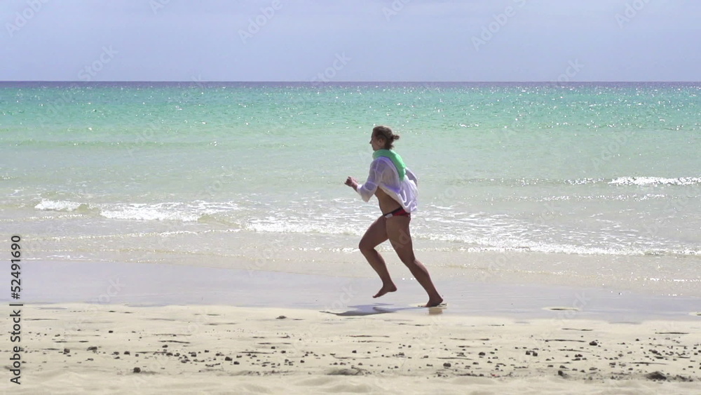 Woman jogging on beautiful topical beach