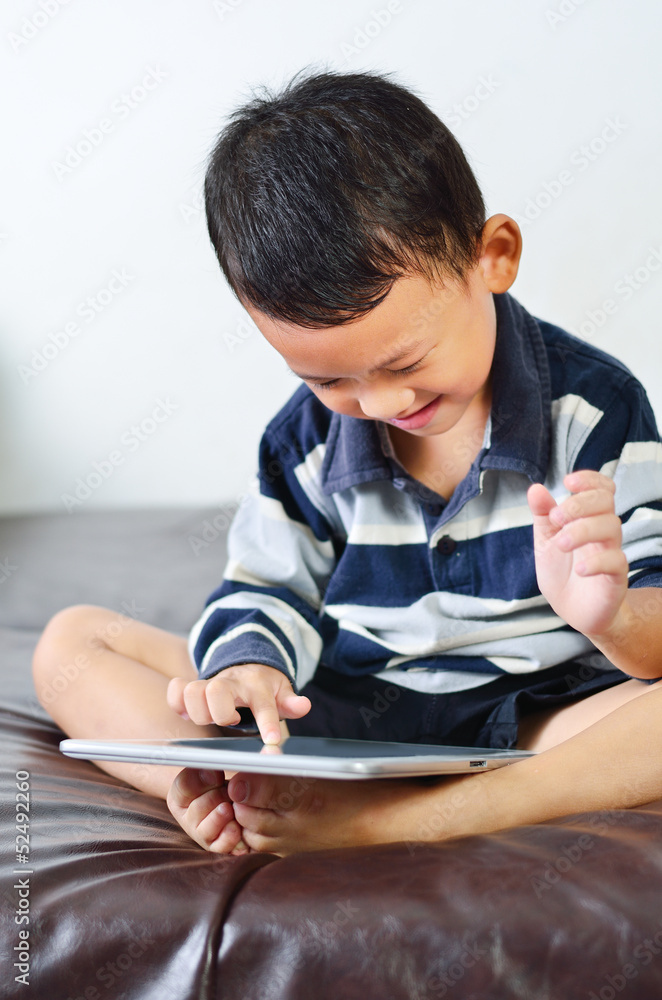 A boy playing a game on computer tablet A boy playing a game on computer tablet