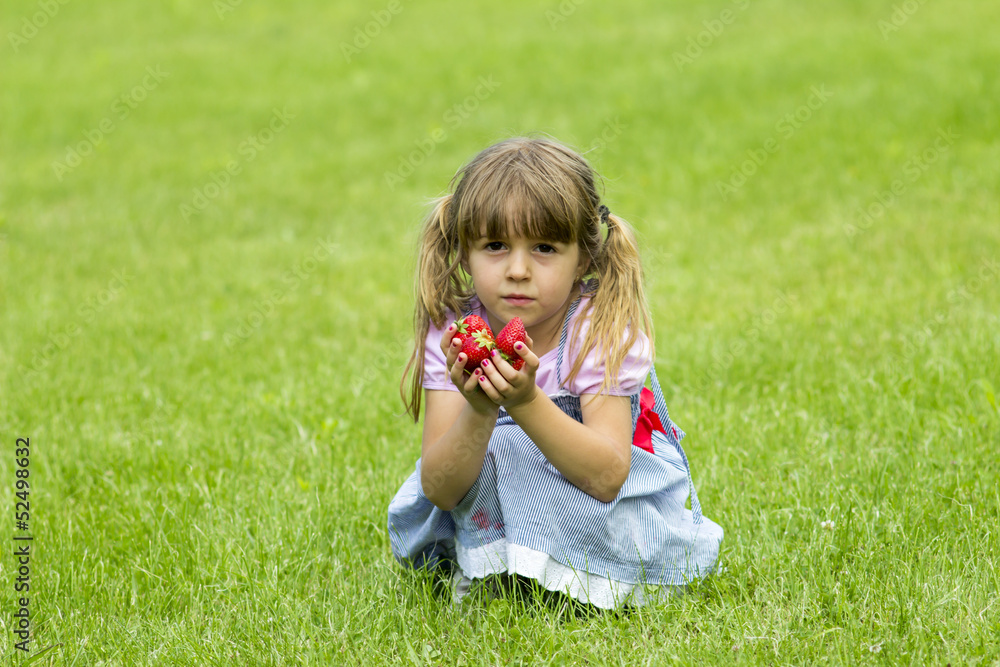 girl holds strawberries