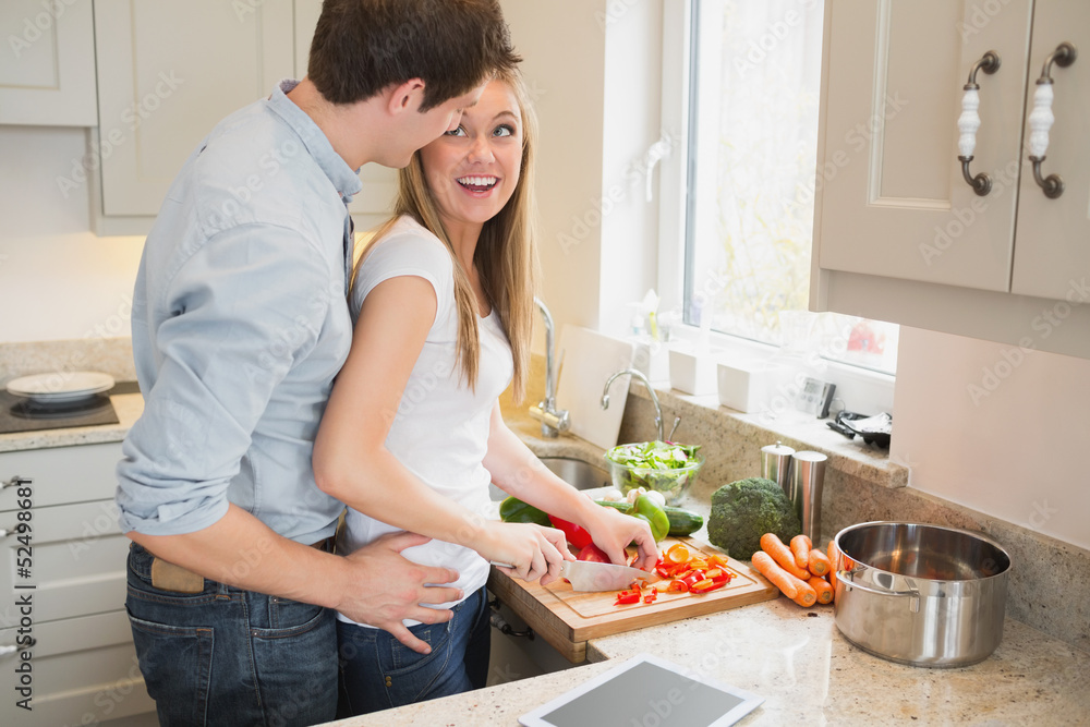Man laughing with woman preparing vegetables Man laughing with woman preparing vegetables