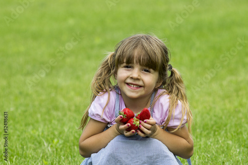Vászonkép girl holds strawberries