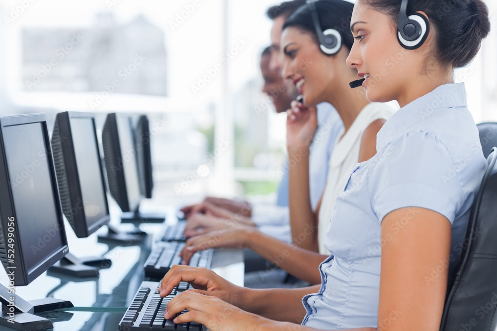 Call centre workers sitting in line while helping people Call centre workers sitting in line while helping people