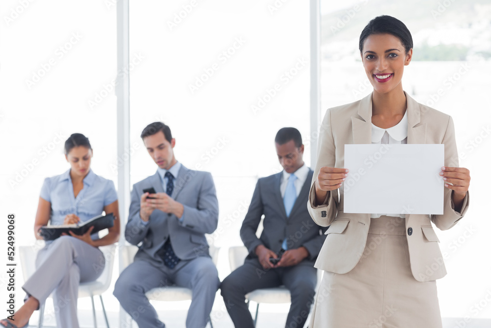 Smiling businesswoman holding a blank notice