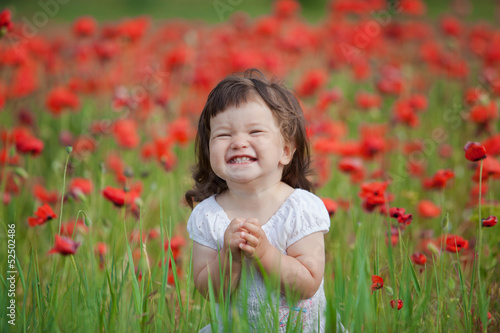 very happy child girl in poppy field