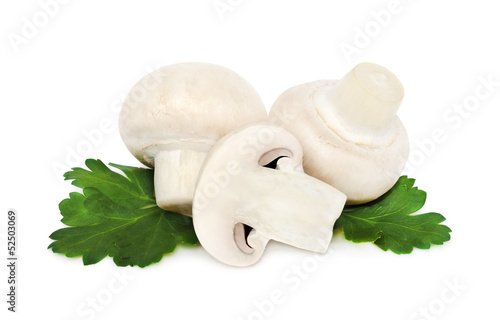 Three champignons on green leaves (isolated)