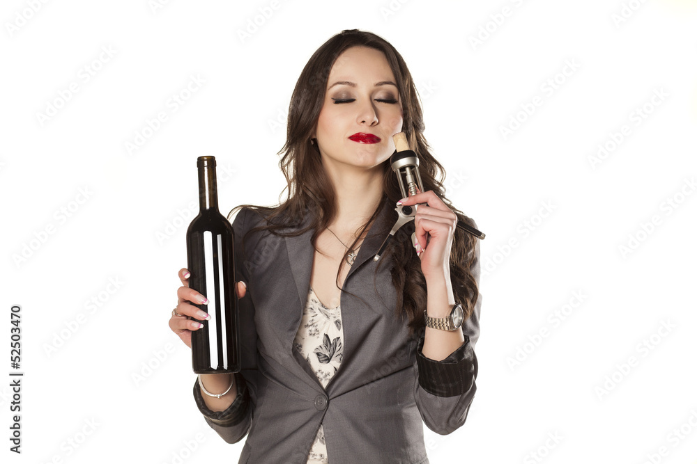 pretty woman holding a bottle of wine and smell the cork pretty woman holding a bottle of wine and smell the cork