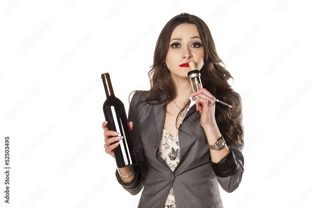 pretty woman holding a bottle of wine and smell the cork pretty woman holding a bottle of wine and smell the cork
