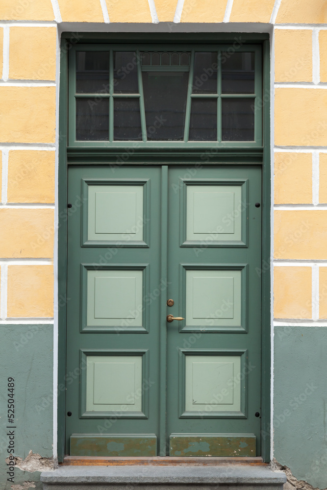 Green door in old building facade. Tallinn, Estonia