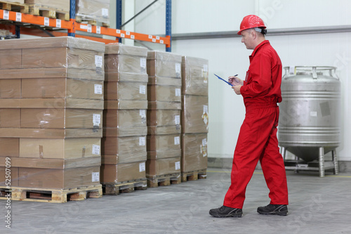 A worker checking stocks in a company warehouse