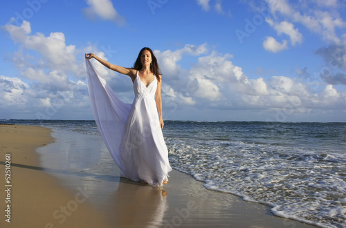 Young woman in white dress on a beach