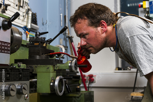 Using an oil can to oil a machine