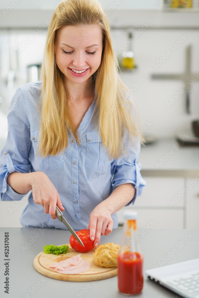 Happy teenager girl making sandwich in kitchen Happy teenager girl making sandwich in kitchen