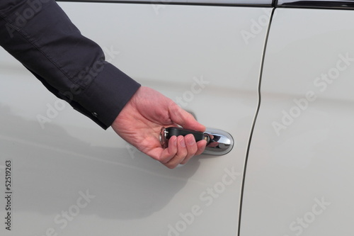 Weisse Autotür wird mit Schlüssel geöffnet