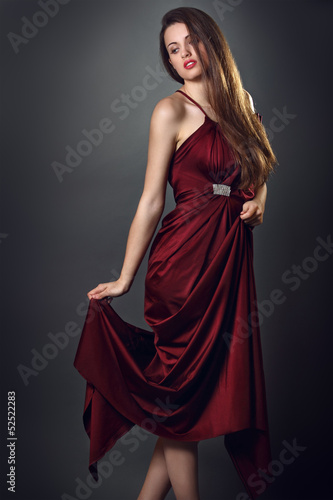 Elegant fashion model poses with red dress of silk © captblack76