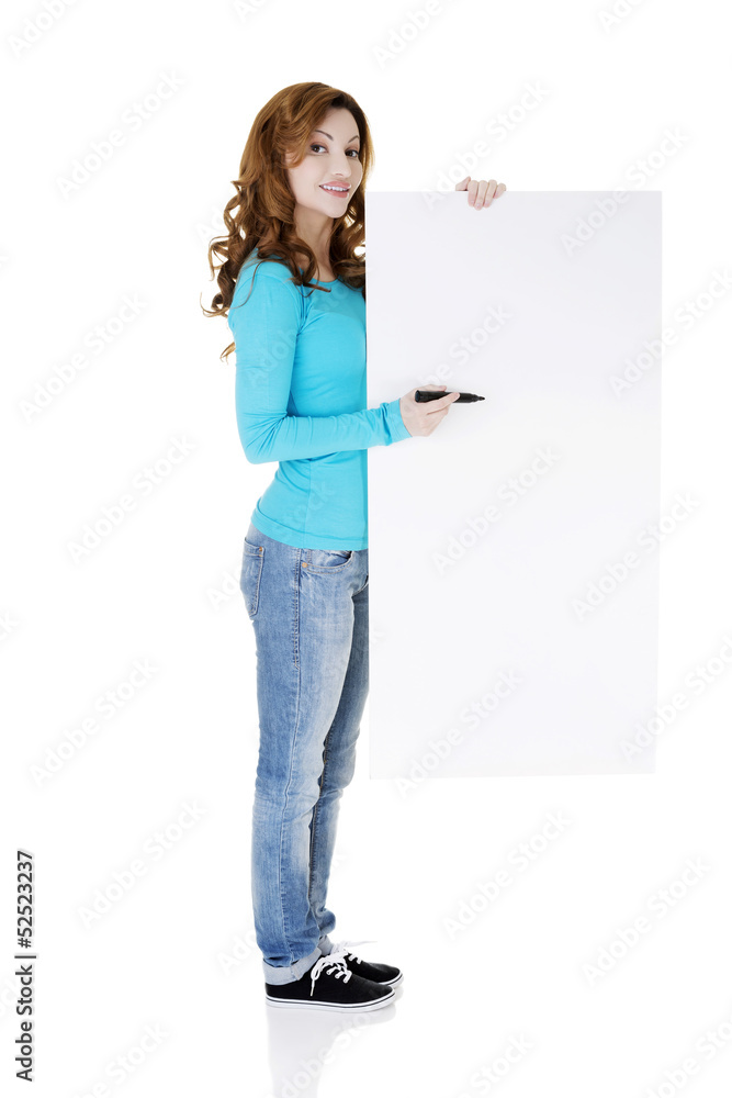 Happy beautiful woman writing with a pen on blank board. Happy beautiful woman writing with a pen on blank board.