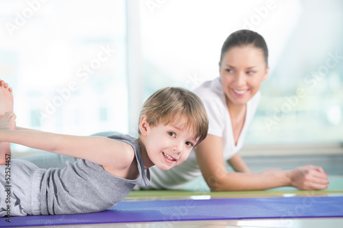 Healthy morning stretching - woman with son doing gymnastic exer