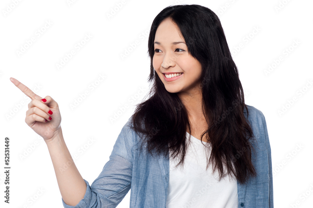 Young chinese girl pointing and looking outside Young chinese girl pointing and looking outside