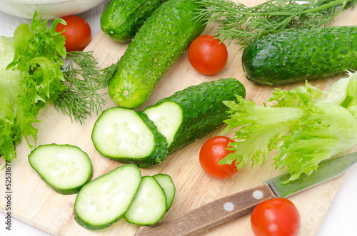 ingredients for salad - fresh cucumbers, tomatoes, herbs