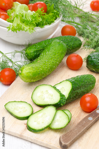 ingredients for salad - fresh cucumbers, tomatoes and herbs