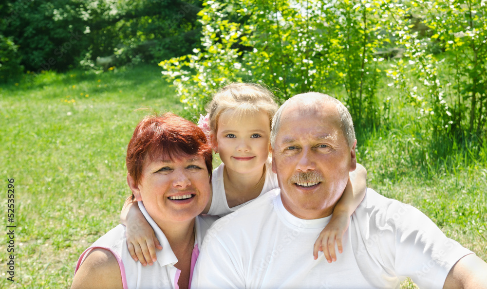 Fototapeta premium Outdoors portrait of grandparents with granddaughter