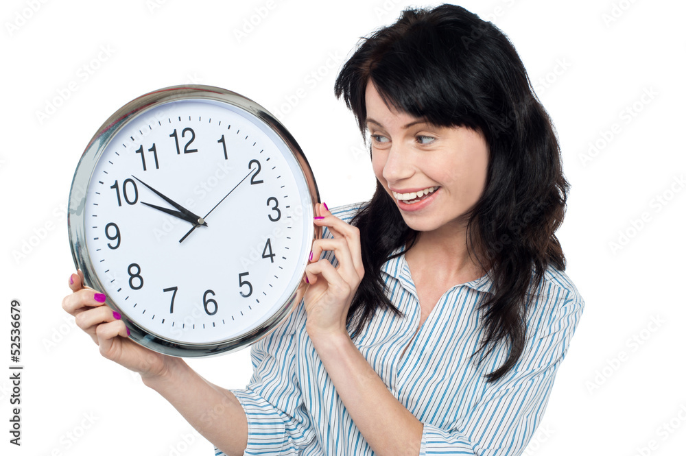 Pretty girl holding and looking at wall clock Pretty girl holding and looking at wall clock