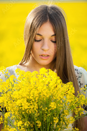 Young woman with a bouquet of yellow wildflowers