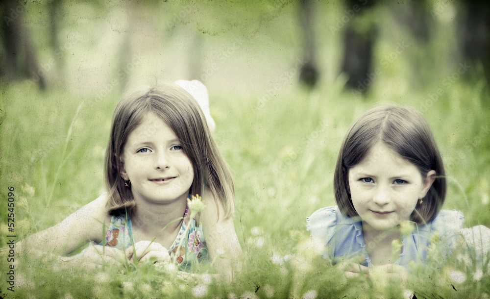 Old photo of happy children lying on green grass outdoors Old photo of happy children lying on green grass outdoors