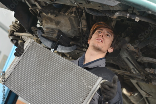 Car mechanic is Changing radiator photo