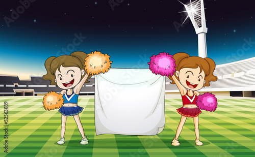 Two cheerdancers holding an empty banner