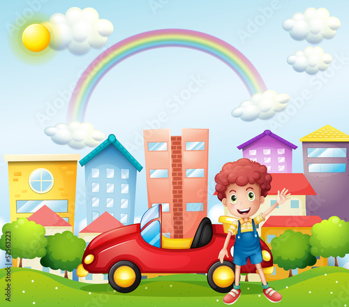 A boy and his red car near the high buildings