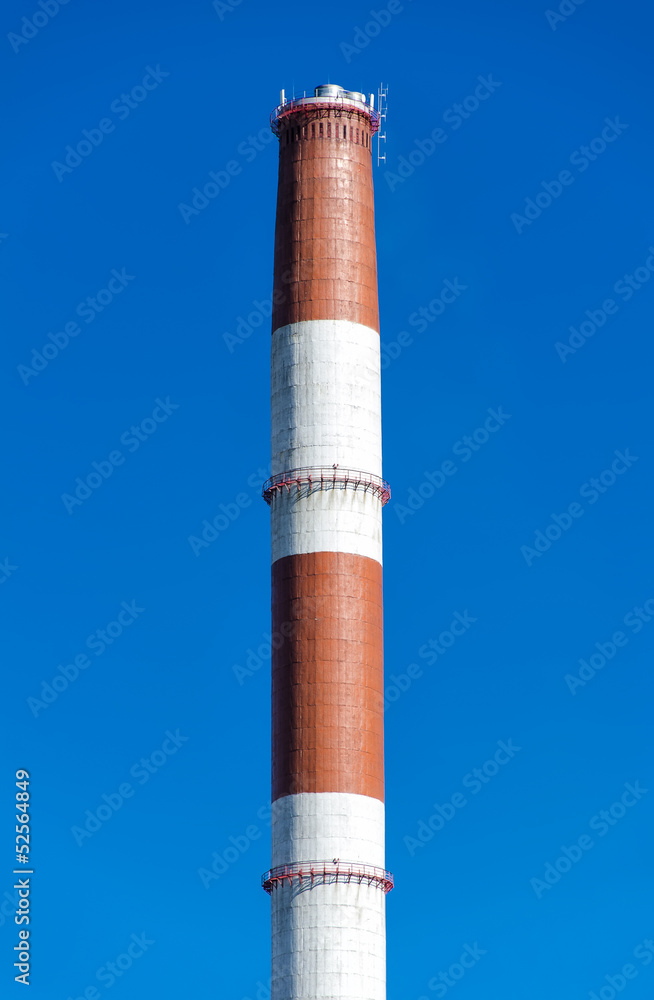 Industrial chimney over blue sky