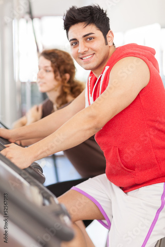 Man is doing workout on a bicycle at the gym