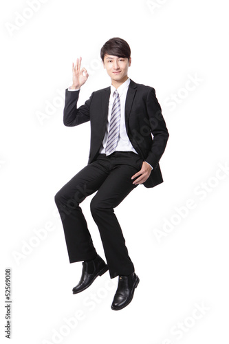 Successful business man sitting on something