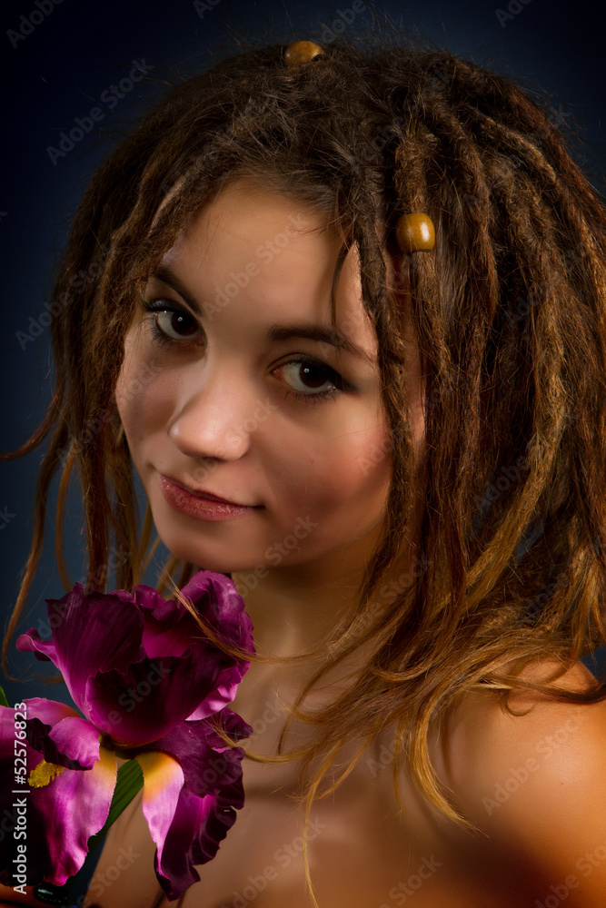 Naklejka premium young woman with dreadlocks against a dark background