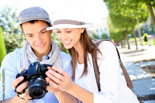 Cheerful couple with photo camera in touristic area