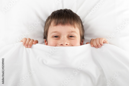 cheerful boy in bed
