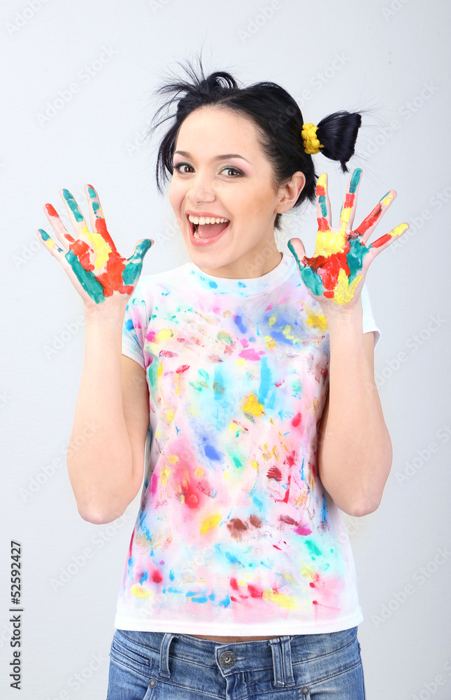 Young pretty painter with hands in paint, on gray background Young pretty painter with hands in paint, on gray background