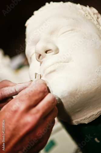 Artist sculpting a face