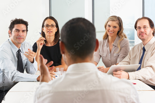View From Behind As CEO Addresses Meeting In Boardroom