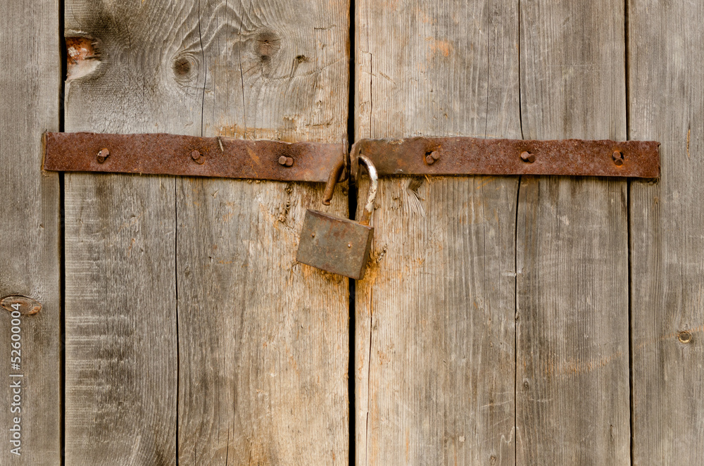 Old rusty padlock on a wooden door Old rusty padlock on a wooden door