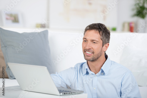 lächelnder mann mit laptop zu hause © contrastwerkstatt