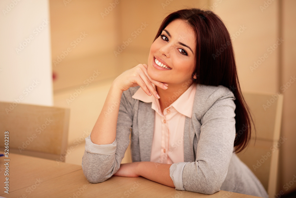 Young confident smiling woman sitting at the table Young confident smiling woman sitting at the table