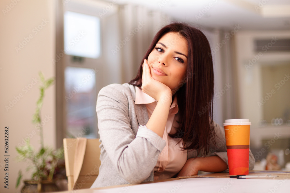 Young confident smiling woman sitting at the table Young confident smiling woman sitting at the table