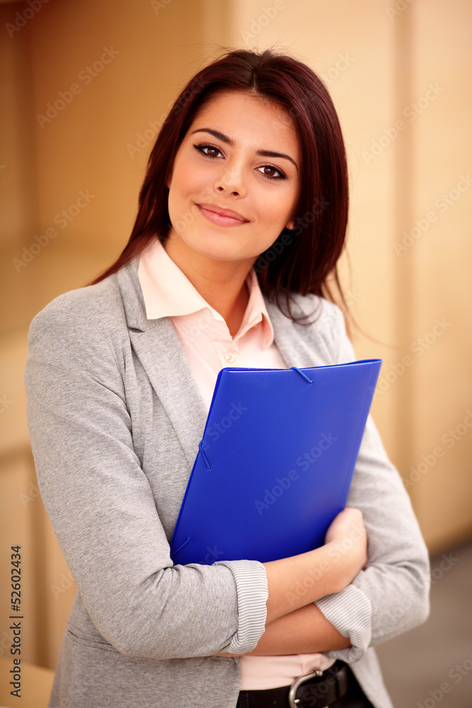 Young happy businesswoman in office holding a folder Young happy businesswoman in office holding a folder