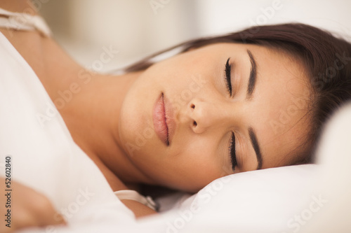 Closeup portrait of a beautiful young woman sleeping on the bed