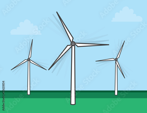 Windmills spinning in a grassy field