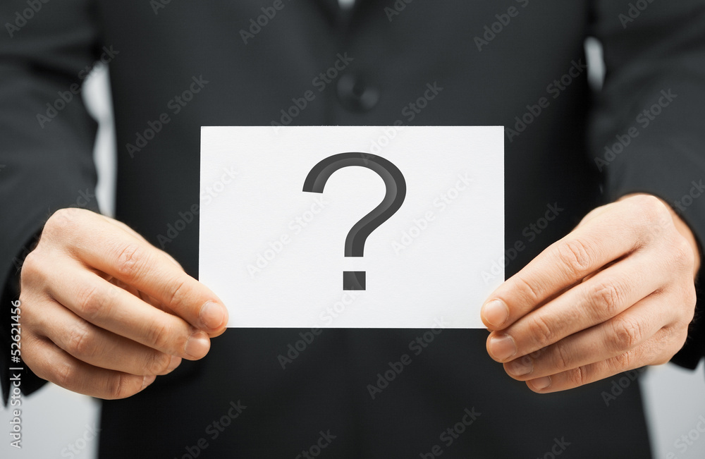 man in suit holding card with question mark man in suit holding card with question mark